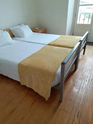 a bedroom with a large bed with white sheets at Azores Youth Hostels - Santa Maria in Vila do Porto