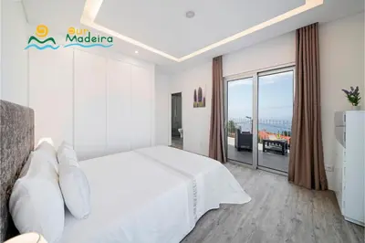 a bedroom with a bed and a swimming pool at OurMadeira - CalhetaScape in Calheta