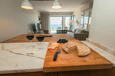 a table with two glasses of wine and a cutting board at Pedra do Jota in Porto Santo
