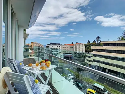 a balcony with a table and chairs and a view of a city at Apartment Sunniva by LovelyStay in Funchal