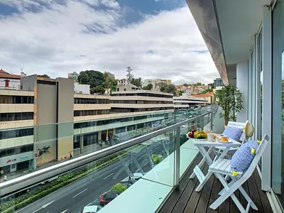 a balcony with a table and chairs and a view of a city at Apartment Sunniva by LovelyStay in Funchal