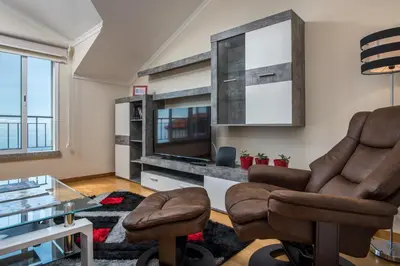 a living room with a television and two chairs at Savana Apartment By Atlantic Holiday in Nogueira