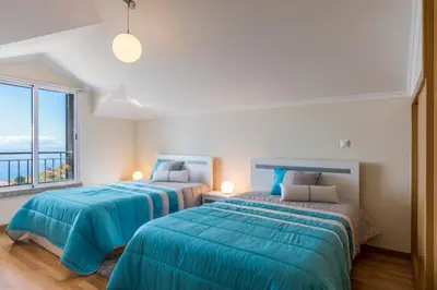 two beds in a room with a window at Savana Apartment By Atlantic Holiday in Nogueira