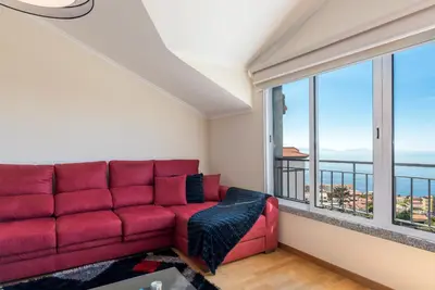a red couch in a room with a large window at Savana Apartment By Atlantic Holiday in Nogueira