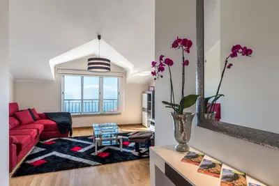 a living room with a red couch and a vase with flowers at Savana Apartment By Atlantic Holiday in Nogueira