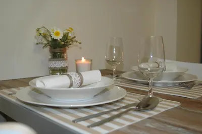a table with plates and wine glasses and a candle at Cantinho do Burgau in Burgau