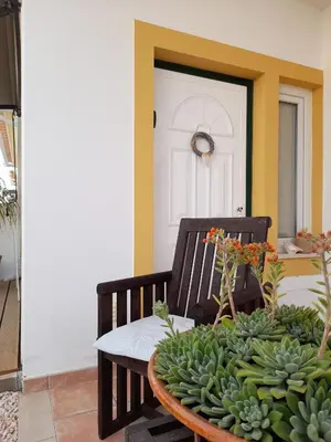 a porch with a table with a bunch of green plants at Cantinho do Burgau in Burgau