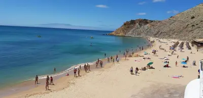 a group of people on a beach near the ocean at Cantinho do Burgau in Burgau