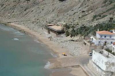 a beach with a person with a yellow umbrella at Cantinho do Burgau in Burgau