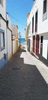 a street with buildings and the ocean in the background at Cantinho do Burgau in Burgau