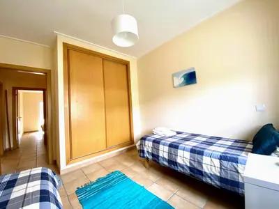 a room with two beds and two blue rugs at Varandas - Arrifana, com piscina, junto à praia in Praia da Arrifana