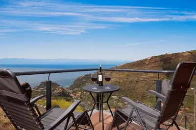 a table and chairs on a balcony with a view of the ocean at SEA VIEW LOFT MADEIRA in Ribeira Brava