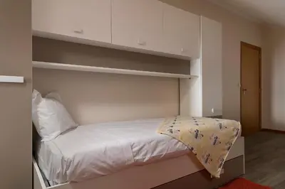 a small bedroom with a bed with white sheets at SEA VIEW LOFT MADEIRA in Ribeira Brava