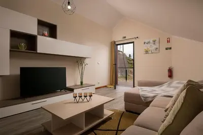 a living room with a flat screen tv and a couch at SEA VIEW LOFT MADEIRA in Ribeira Brava