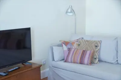 a living room with a couch with a television and pillows at Heritage Apartments in Funchal
