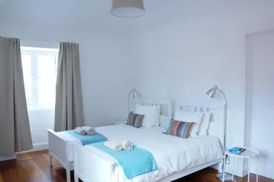 a bedroom with a white bed with two towels on it at Heritage Apartments in Funchal