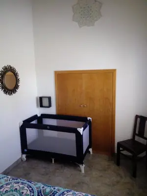 a bedroom with a bed and a wooden door at O Nosso Lar in Lagos