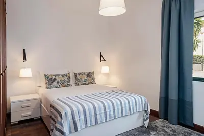 a white bedroom with a bed and a window at Garajau II by An Island Apart in Caniço