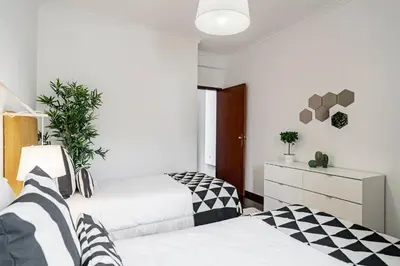 two beds in a bedroom with black and white at Garajau II by An Island Apart in Caniço