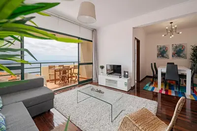 a living room with a couch and a dining room at Garajau II by An Island Apart in Caniço
