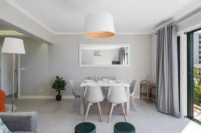 a white dining room with a white table and chairs at Promenade I by An Island Apart in Funchal