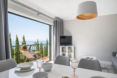 a dining room with a table and a large window at Promenade I by An Island Apart in Funchal