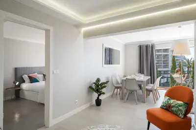 a living room with a table and a bedroom at Promenade I by An Island Apart in Funchal