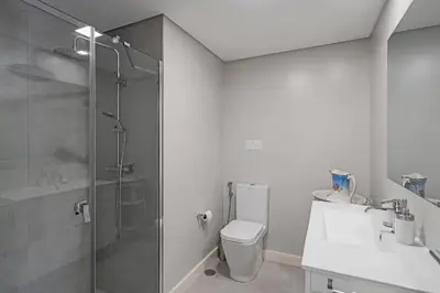 a bathroom with a shower and a toilet and a sink at Promenade I by An Island Apart in Funchal