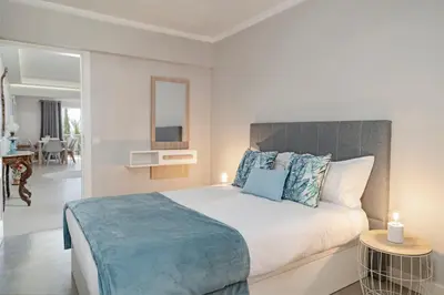 a bedroom with a large bed with blue pillows at Promenade I by An Island Apart in Funchal