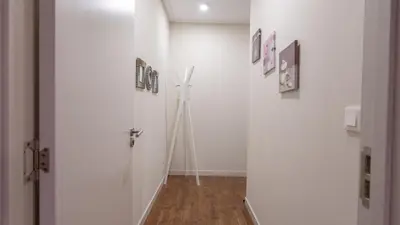 a hallway with a white wall with pictures on it at Gardenia Apartment by LovelyStay in Funchal