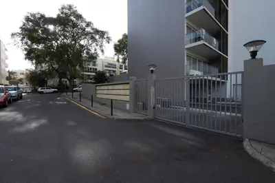 a parking lot with a white fence next to a building at Gardenia Apartment by LovelyStay in Funchal