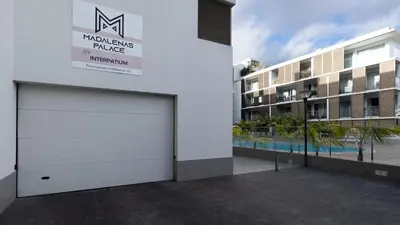 a white garage door in front of a building at Gardenia Apartment by LovelyStay in Funchal