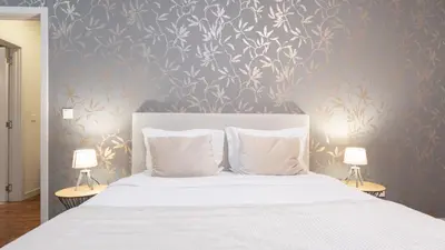 a bedroom with a white bed with two lamps at Gardenia Apartment by LovelyStay in Funchal