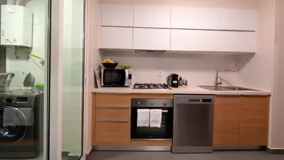 a kitchen with white cabinets and a stove top oven at Gardenia Apartment by LovelyStay in Funchal
