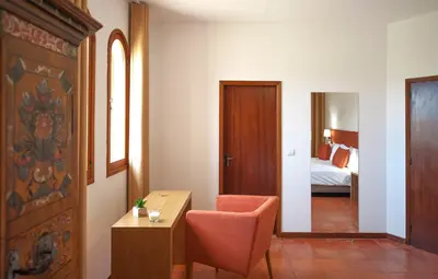 a hotel room with a desk and a bedroom at Theresia's in Porto Santo