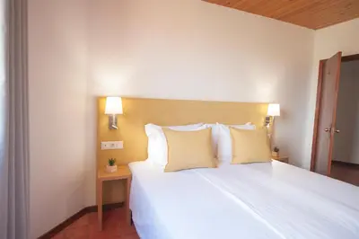 a bedroom with a large white bed with two pillows at Theresia's in Porto Santo