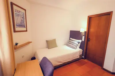 a small room with a small bed and a table at Theresia's in Porto Santo