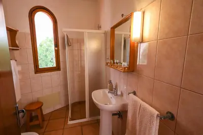 a bathroom with a sink and a shower with a mirror at Theresia's in Porto Santo