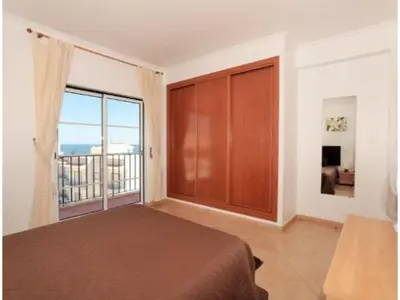 a bedroom with a bed and a large window at ST JAMES in Luz