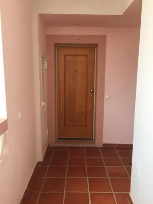 a hallway with a wooden door and a tile floor at ST JAMES in Luz