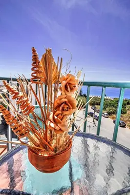 a vase with flowers on a table on a balcony at ST JAMES in Luz