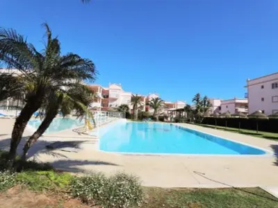a large swimming pool with a palm tree and buildings at ST JAMES in Luz