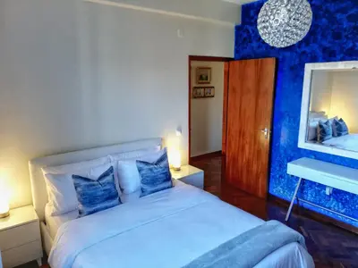 a blue bedroom with a bed and a mirror at Atlantic house in Gaula