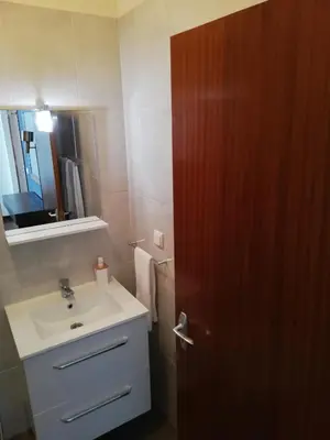 a bathroom with a sink and a wooden door at Atlantic house in Gaula