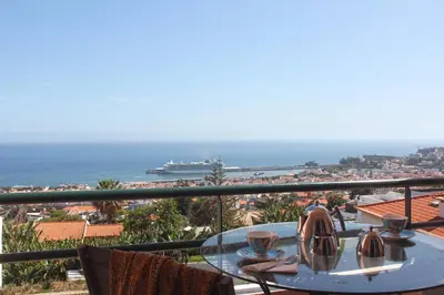 a table with two cups on top of a balcony at Stylish apartment with balcony and amazing views over Funchal and the sea in Funchal