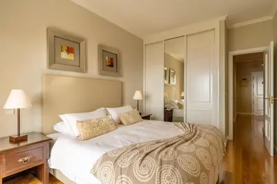 a bedroom with a large white bed and a night stand at Stylish apartment with balcony and amazing views over Funchal and the sea in Funchal