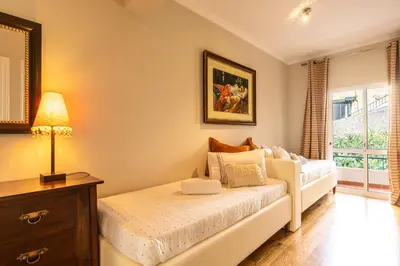 a bedroom with a bed and a lamp and a window at Stylish apartment with balcony and amazing views over Funchal and the sea in Funchal