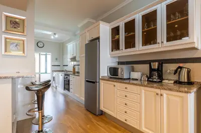 a kitchen with white cabinets and stainless steel appliances at Stylish apartment with balcony and amazing views over Funchal and the sea in Funchal