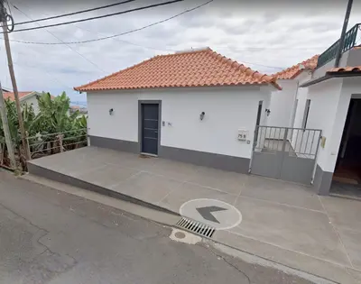 a white house with a door and a driveway at Lucas House in Ponta do Sol