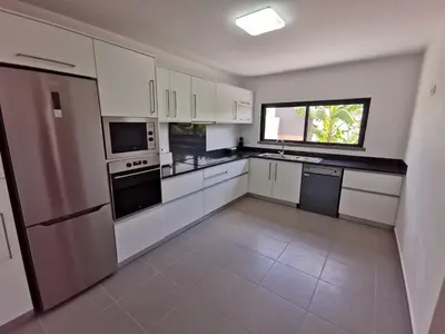 a large kitchen with white appliances and a window at Lucas House in Ponta do Sol